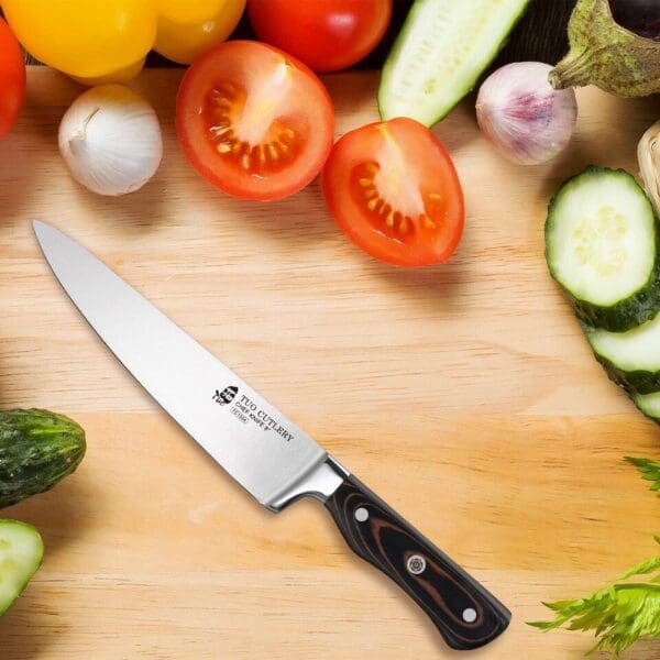 A knife and some vegetables on top of a cutting board.