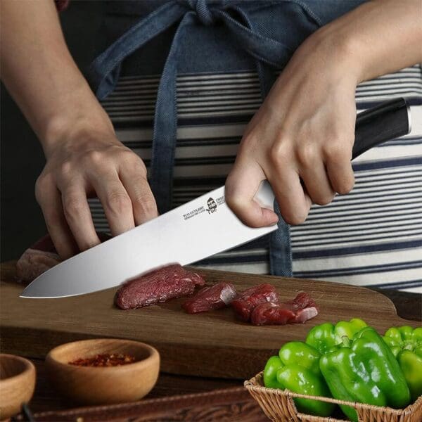 A person slicing meat on top of a cutting board.