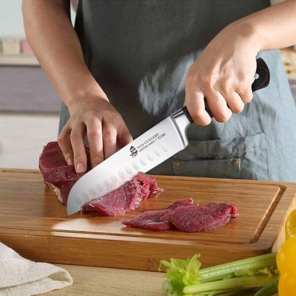 A person is cutting meat on a wooden board