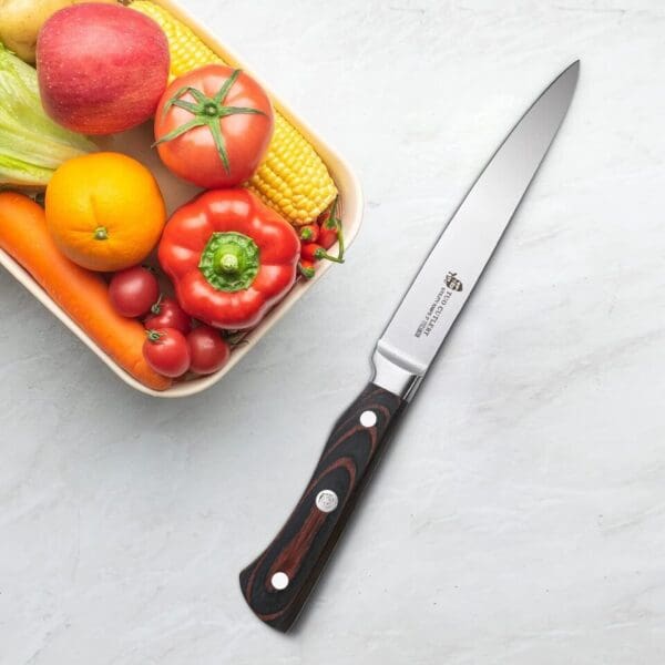 A knife and bowl of fruit on the table